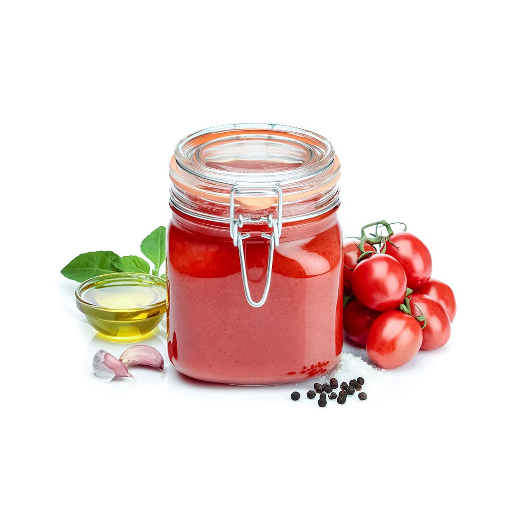 sos pomidorowy w słoiku obok pomidorów i oliwy